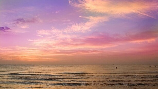 A sunset over a calm sea with a clear sky. - Cozy and friendly. All is Well - no damage (Clearwater Beach)