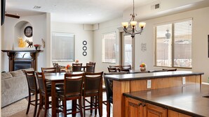 Una cocina amplia con una isla grande, armarios de madera y un comedor con sillas y una mesa.
