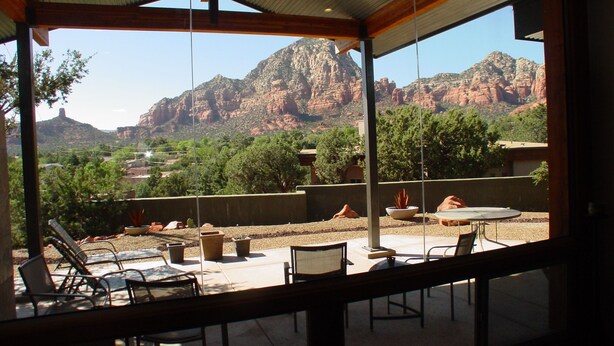 A covered outdoor seating area with a view of red rock formations. - Beauty and the Beast Stunning Home, Stunning Views, Walk to Town Weekly Discount (Sedona)