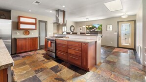 A spacious kitchen with a large island, built-in oven, and a stainless steel range hood. - Beauty and the Beast Stunning Home, Stunning Views, Walk to Town Weekly Discount (Sedona)
