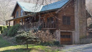 A log cabin with a metal roof, a porch, and a stone chimney. - Southern Charm, beautiful cabin close to Pigeon Forge and Gatlinburg (Sevierville)