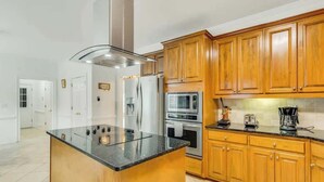 A kitchen with wooden cabinets, stainless steel appliances, and a granite countertop.