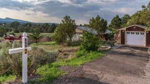 A rural property with a gravel driveway, a garage, and a small shed. - Albuquerque East Mountains (Sandia Park)