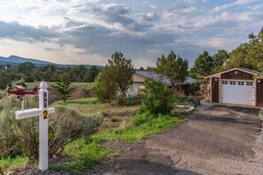 A rural property with a gravel driveway, a garage, and a small shed. - Albuquerque East Mountains (Sandia Park)