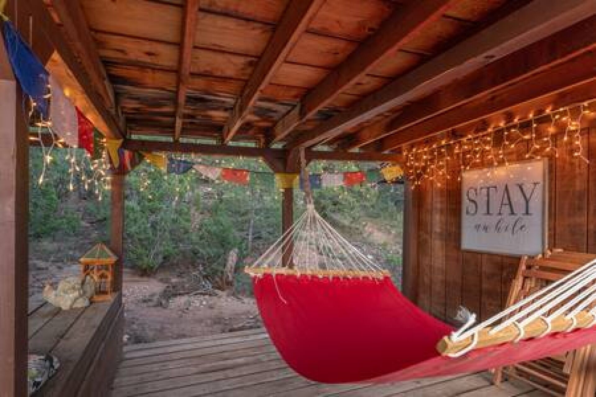 Un hamac suspendu sous une structure en bois, avec une pancarte sur laquelle on peut lire : « VIVEZ pleinement. »