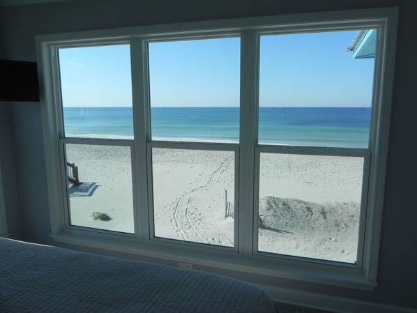 Ein Zimmer mit großem Fenster und Blick auf den Strand.