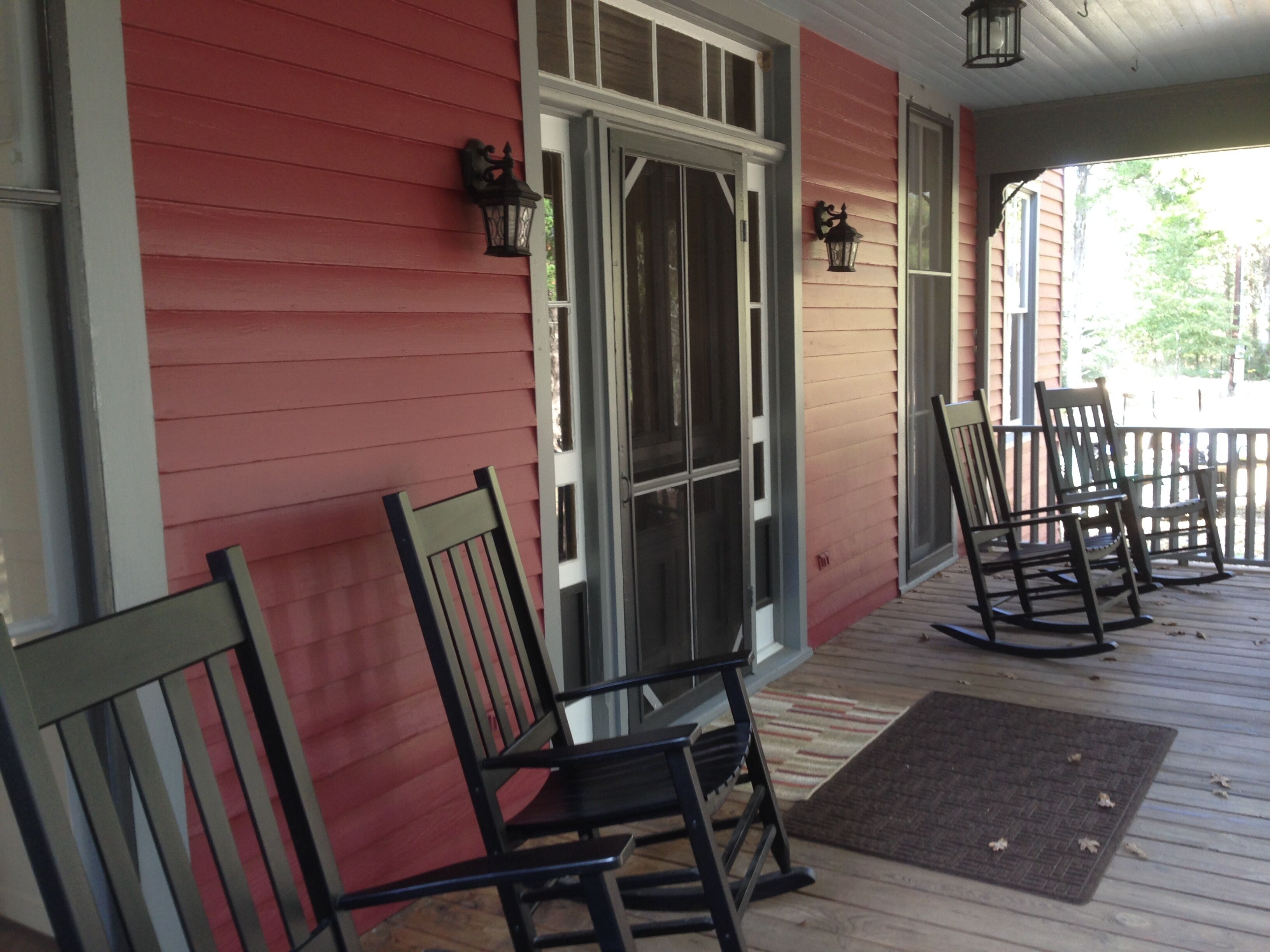 rocking chairs on the porch overlooking trees and pond.