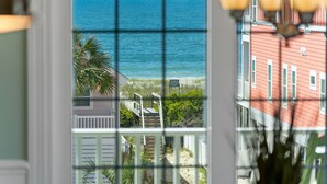 A view of a beach with a wooden staircase leading down to the sand, a 'KEEP OFF DUNES' sign, and a red building in the background. - "Tides a Wastin' " Private Pool w/Opt Heat, Hot Tub, Tiki Bar, Elevator (Holden Beach)