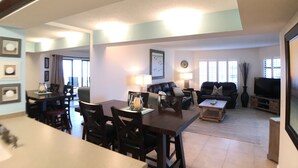 A spacious living room with a dining area, a television, and a fireplace.