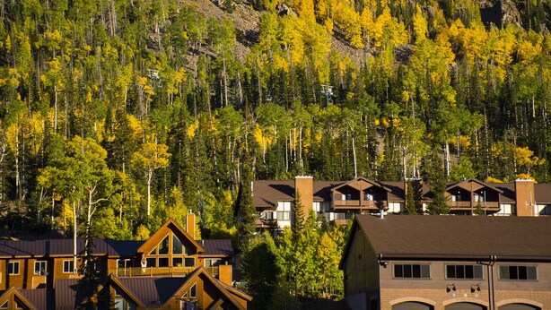 A lodge with multiple wooden cabins, a mountain backdrop, and a clear sky. - Ski, Hike, Fun - Great Location!!  Perfect 2 Br/2 Ba Condo! (Brian Head)