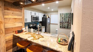 A kitchen with wooden accents, a granite countertop, and modern appliances. - Ski, Hike, Fun - Great Location!!  Perfect 2 Br/2 Ba Condo! (Brian Head)