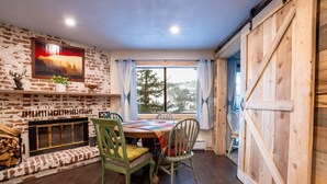 A cozy dining area with a wooden table, chairs, and a fireplace. - Ski, Hike, Fun - Great Location!!  Perfect 2 Br/2 Ba Condo! (Brian Head)