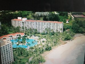 A large hotel with multiple floors, a central swimming pool, and surrounding greenery. - Marriott Kauai Beach Club, Ocean View Studio.  Available Christmas Week! (Lihue)