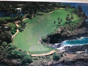 An aerial view of a golf course with a water body and rocky terrain. - Marriott Kauai Beach Club, Ocean View Studio.  Available Christmas Week! (Lihue)