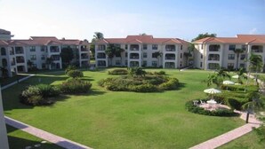 A courtyard with a central lawn, surrounded by multi-story buildings with balconies.