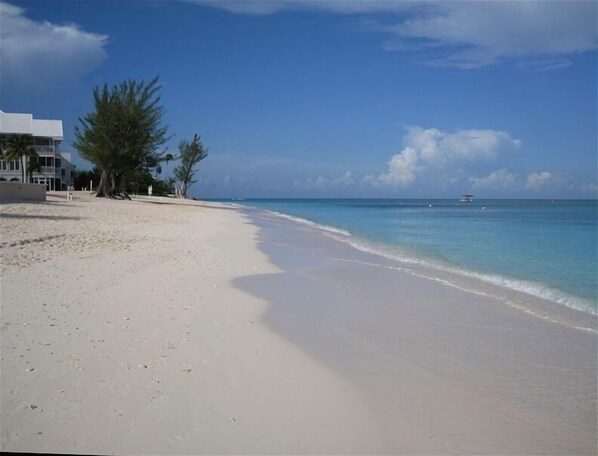 Enjoy a serene beach experience with a wide sandy shore and calm sea.