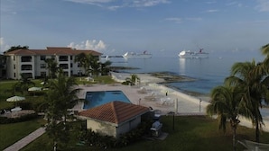 A resort with a swimming pool, beach, and ocean view.