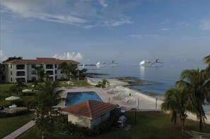 Relax by the pool overlooking the calm sea with stunning views of cruise ships in the distance.