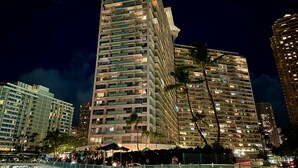 A high-rise hotel with multiple balconies, a pedestrian bridge, and surrounding palm trees. - Family friendly unit with fabulous Ocean/Lagoon view  (Honolulu)