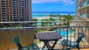 A balcony with a table and chairs overlooking a beach and ocean. - Family friendly unit with fabulous Ocean/Lagoon view  (Honolulu)