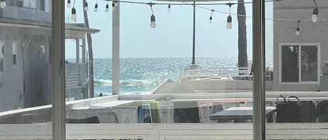 A view from a balcony with a railing, overlooking a boat and the sea.