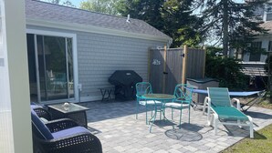 A patio with outdoor furniture, a barbecue grill, and a sliding glass door to a house. - Great Location, Beach 4 minutes walk, Large Patio and Parking for one vehicle. (Dennis)