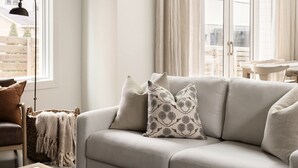 Un salon avec un canapé, une table basse et une fenêtre avec des rideaux.