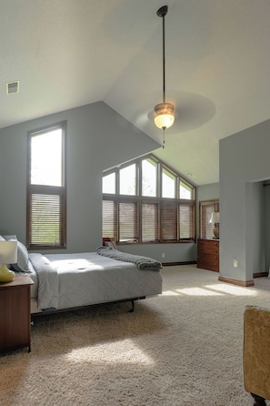 A bedroom with a bed, a nightstand, a dresser, a lamp, and a ceiling fan. - 5 bedroom 3 level home that is great for groups of all kinds friends and family (Galena)