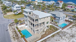 Ein mehrgeschossiges Wohngebäude mit Pool in einer Küstenlage mit Blick auf das Meer.
