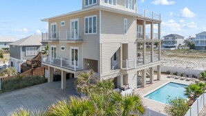 Ein mehrstöckiges Strandhaus mit Pool, Balkonen und einer Holzterrasse.