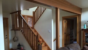 A wooden staircase with a handrail, a small table with a lantern, and a cushioned seating area. - Multi-Family Getaway at Raystown Lake in Central PA (Entriken)