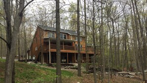 A two-story wooden cabin surrounded by trees. - Multi-Family Getaway at Raystown Lake in Central PA (Entriken)