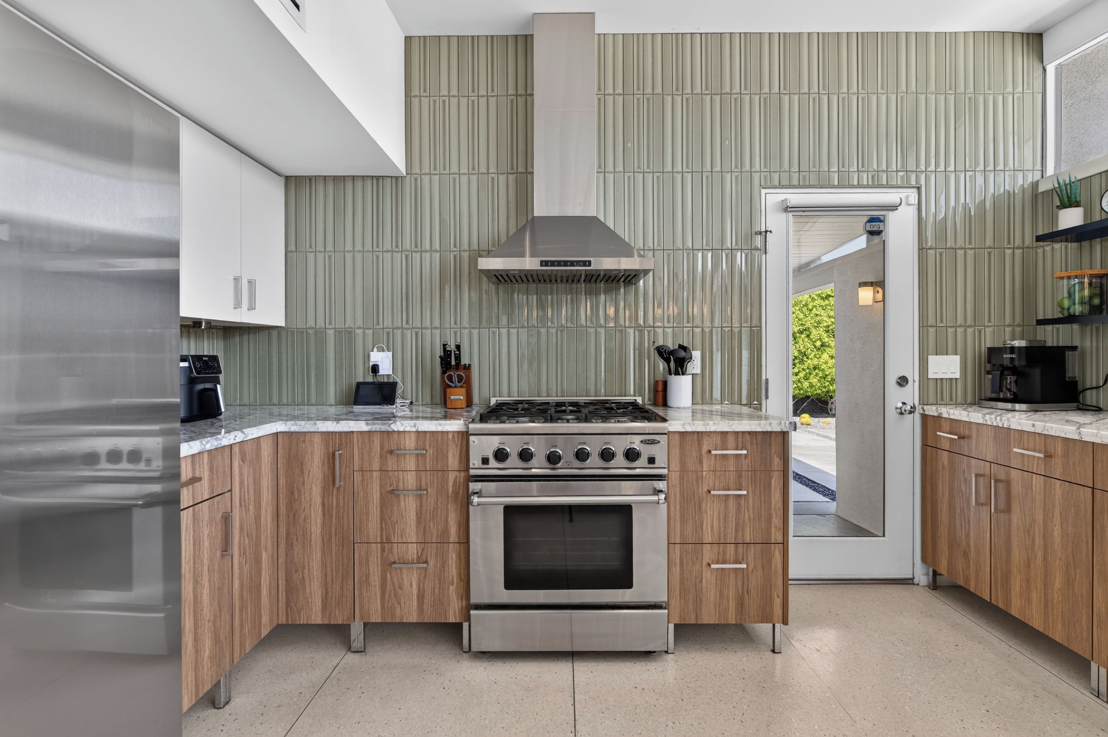 Una cocina moderna con horno empotrado, estufa de acero inoxidable y armarios de madera.