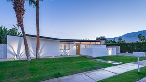 A modern house with a well-maintained lawn, a driveway, and a mailbox. - PS Chill: Meticulous Mid-Century Features Modern Comfort and Views! (Palm Springs)