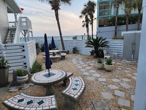Enjoy ocean views from this patio with a mosaic-tiled table, potted plants, and comfortable seating.