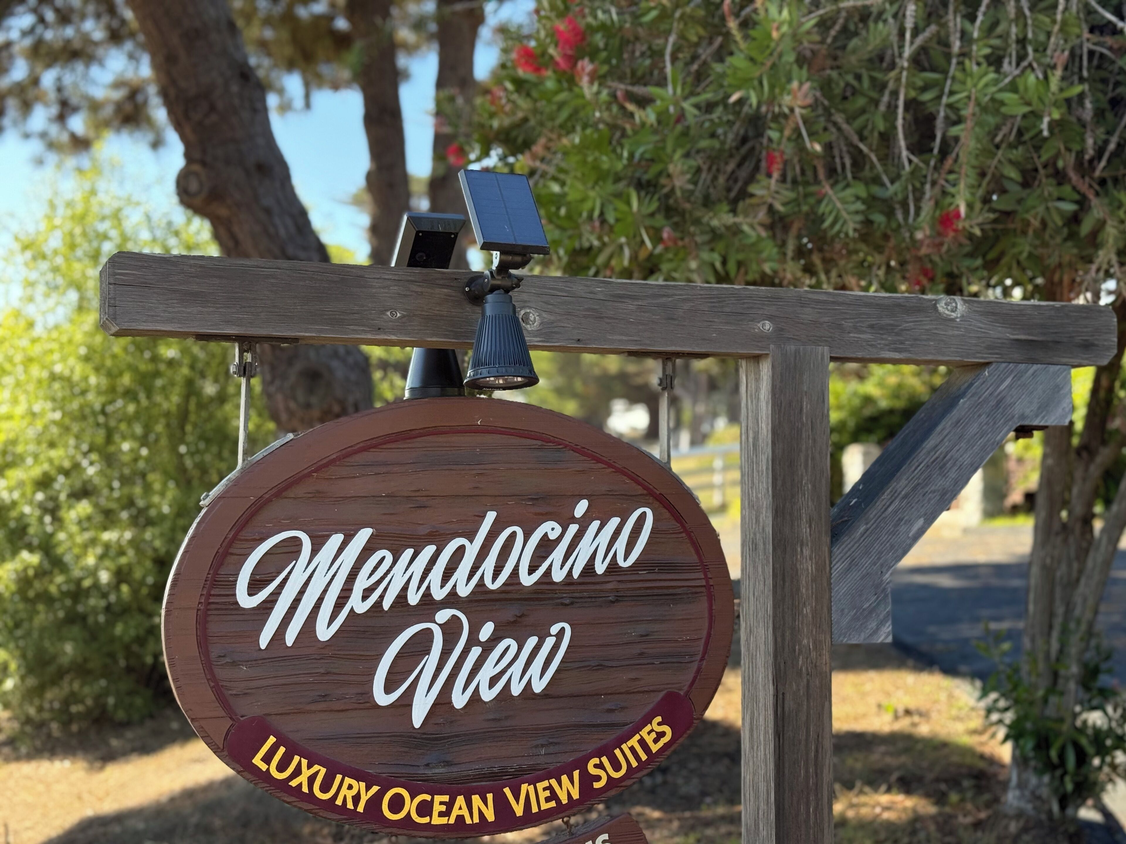 Placa de madeira com 'Mendocino View' e 'Suítes de Luxo com Vista para o Oceano', indicando um hotel ou resort.