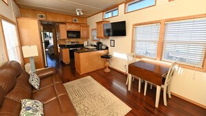 A compact RV interior with a kitchenette, dining area, and living space. - Rebel's Rest - A Romantic Getaway Houseboat w/ New Water Filtration System (Apalachicola)
