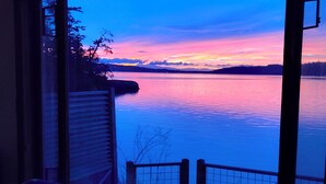 Una habitación con vistas a un lago al atardecer.