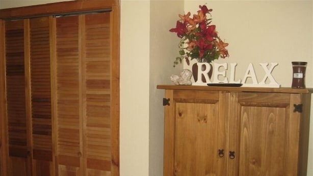 Un meuble en bois orné d’un arrangement floral et sur lequel est inscrit le mot « RELAX ».