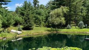 A serene pond surrounded by lush greenery and trees. - Beautifully secluded getaway perfect for all seasons! (Adams)