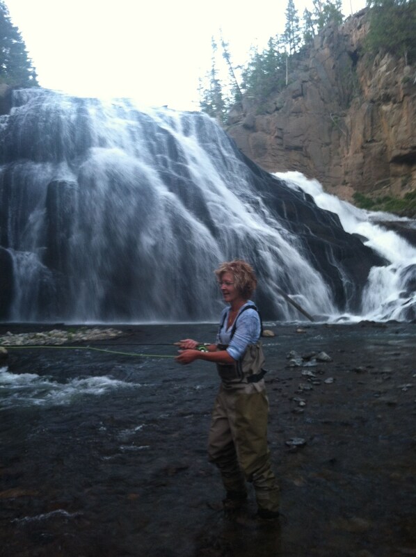 A person standing in front of a waterfall.