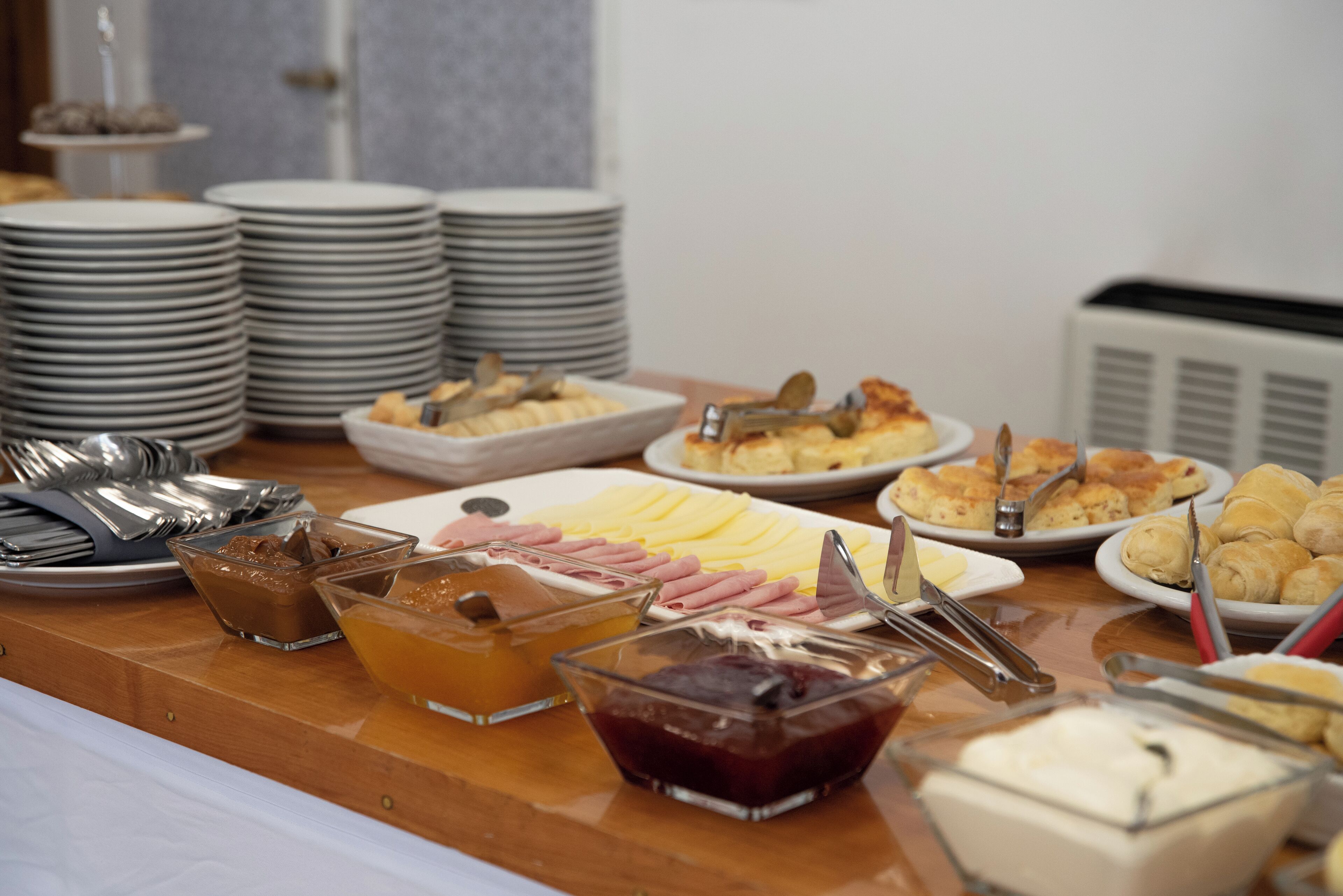 A buffet table with various food items and utensils.