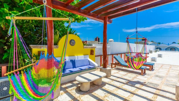 A covered outdoor seating area with hammocks, a bench, and a sofa. - One Bedroom Suite, Serene, Pool, Gardens, Rooftop Terrace with Views (Isla Mujeres)