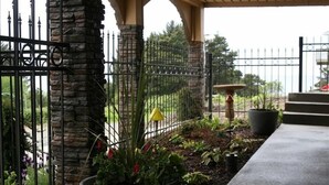 A stone pillar, a metal fence, and a planter with flowers. - Majestic View, Luxury Home, Corp Retreat, Sauna, Roads End (Lincoln City)