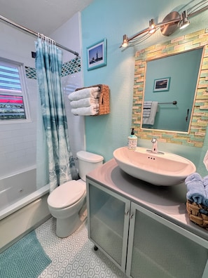 A bathroom with a toilet, sink, and shower curtain.