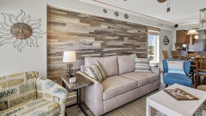 Ein Wohnzimmer mit Holzwandpaneel, einer Couch, einem blauen Sessel, einem Couchtisch und einer Lampe.
