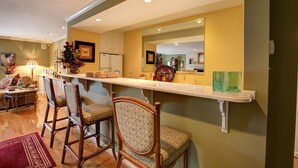 A dining area with a long counter, three chairs, and a mirror above. - family vacation, BOATING, with heated pool Waterfront Lake wylie home -hot tub  (Charlotte)