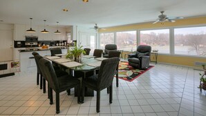 A spacious kitchen with modern appliances, a dining area with a large table and chairs, and a view of a lake through large windows. - family vacation, BOATING, with heated pool Waterfront Lake wylie home -hot tub  (Charlotte)