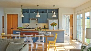 A modern kitchen with blue cabinets, a wooden island, and pendant lighting. - Modern Farmhouse on 25 Acres / Superb Views. (Rochester)