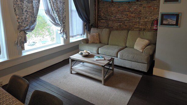 Ein Wohnzimmer mit einer Couch, einem Couchtisch und einer Surfbrett-Dekoration an der Wand.